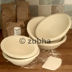 Round wood pulp bannetons on worktop, 500g and 1kg sizes, various patterns